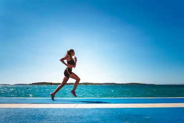 Woman running showing strong leg muscle St Helens